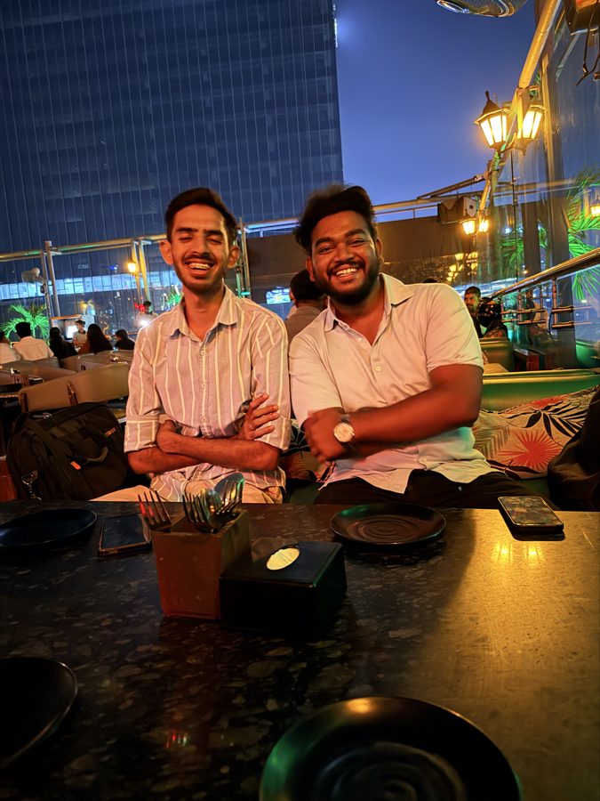 Jai with a friend at a café at night